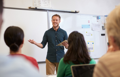 Teacher standing in front of class teaching students