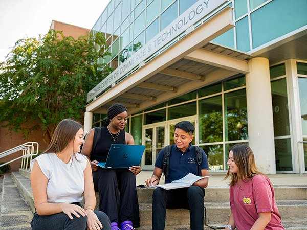Students sitting together by the CCT building.