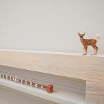Small deer figurine and miniature objects arranged on gallery shelf