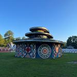 Wide view of the round pagoda building with colorful painted walls against a clear blue sky