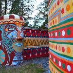 Colorful painted totem with face design and geometric-patterned cylindrical walls