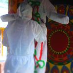 Person painting another person's outfit at a Pasaquan event