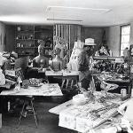 Black and white photo of Eddie Martin working in his art studio surrounded by sculptures