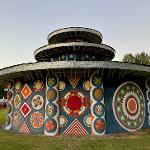 Round pagoda building with colorful medallion murals at dusk