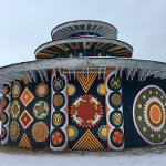 Round pagoda building covered in snow with colorful medallion paintings visible
