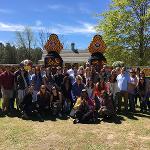 Group of visitors posing for a photo at Pasaquan's colorful totem entrance