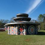 Three-tiered round pagoda building with colorful geometric medallion paintings on a sunny day