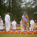 Performers in white clothing on the colorfully painted stage at Pasaquan