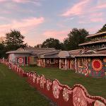 Pasaquan compound at sunset with pink sky showing decorated walls, buildings, and pagoda