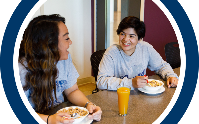 Two students eating and talking to each other