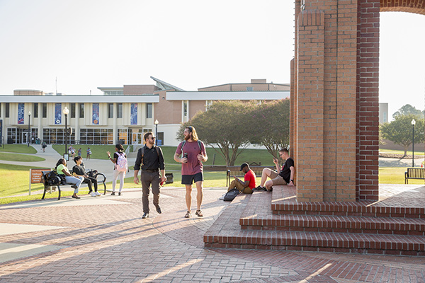 Several students walking and sitting near the clocktower