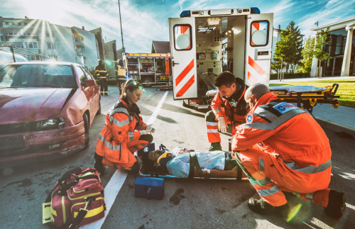 Paramedics at the scene of a car crash helping a victim on a stretcher