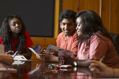 Three students discussing a brochure