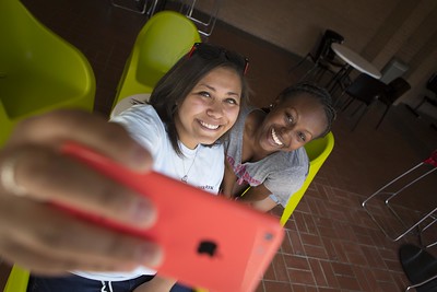 Two female students holding up a phone taking a selfie