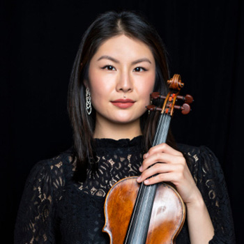 a woman in a black dress holding a violin