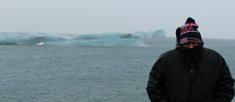 a man in a jacket in front of icebergs