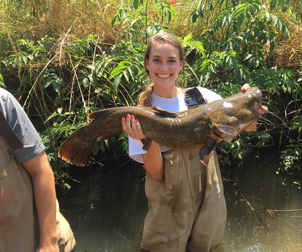 A female student holding a catfish