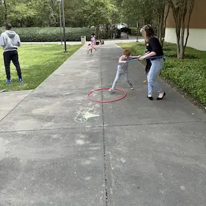 young students playing outside with instructors