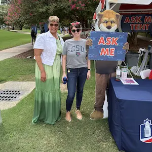 two women standing next to cody the cougar