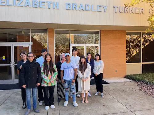 Group of international students posing for the camera in front of the Elizabeth Bradley Turner Center
