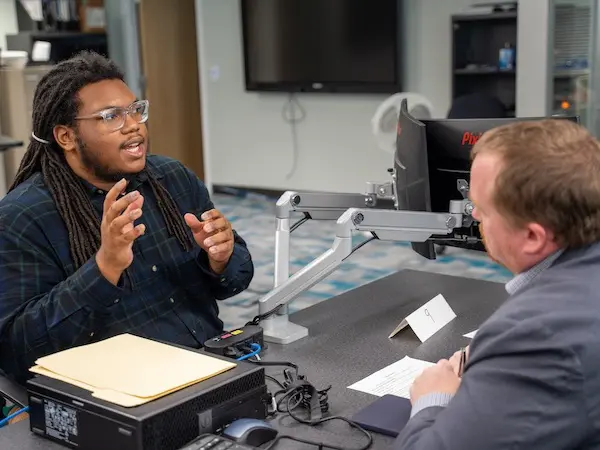 A student mock interviewing with a local professional