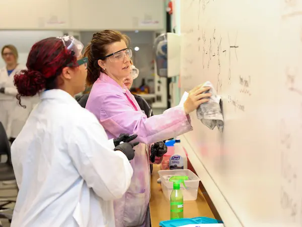 Chemistry professor teaching on a white board