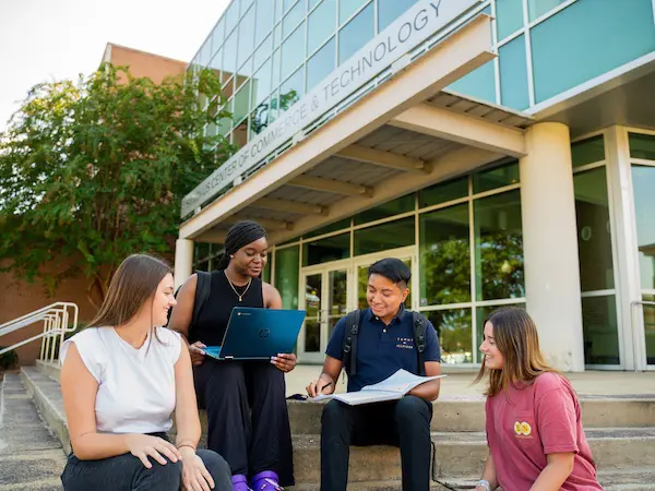 Students sitting outside of the business building