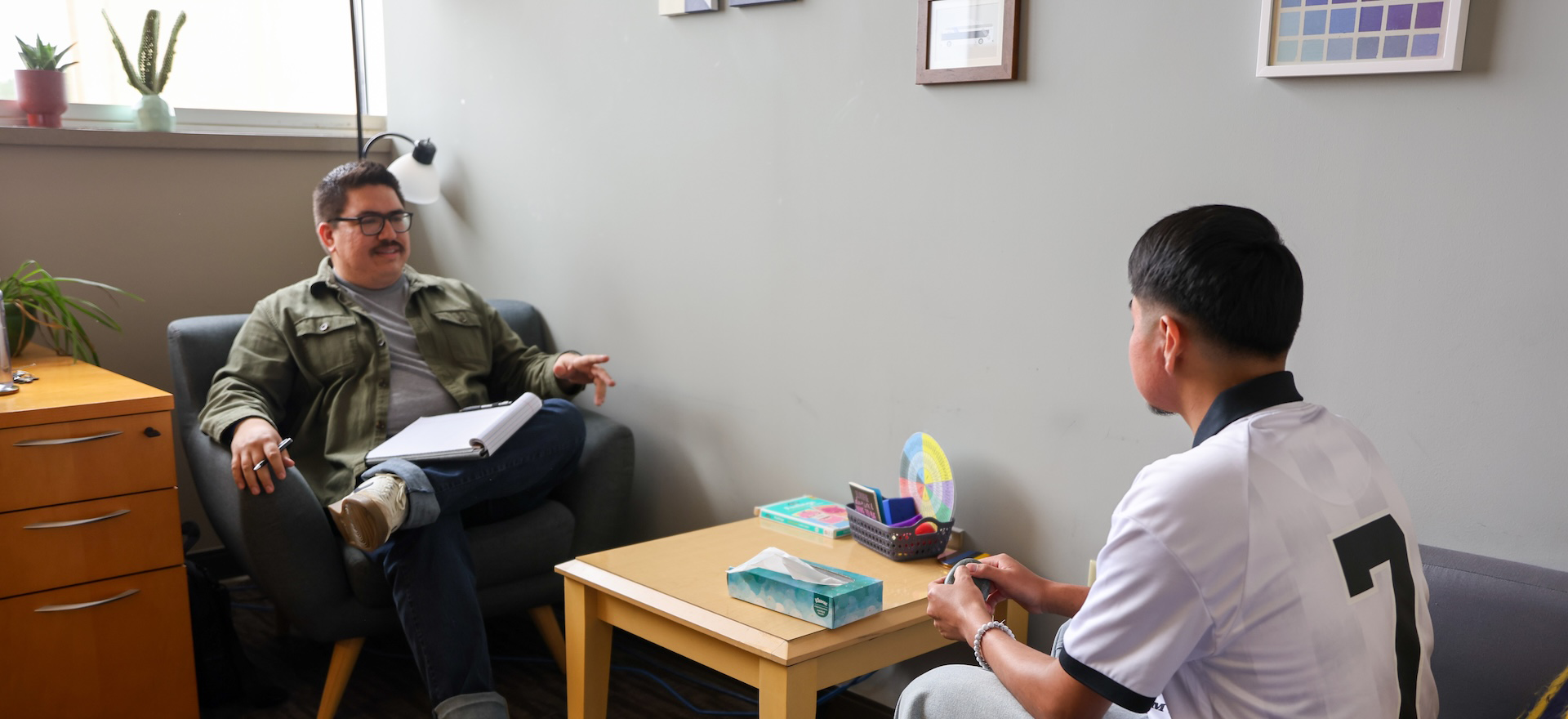 a counseling sitting in his office with a patient