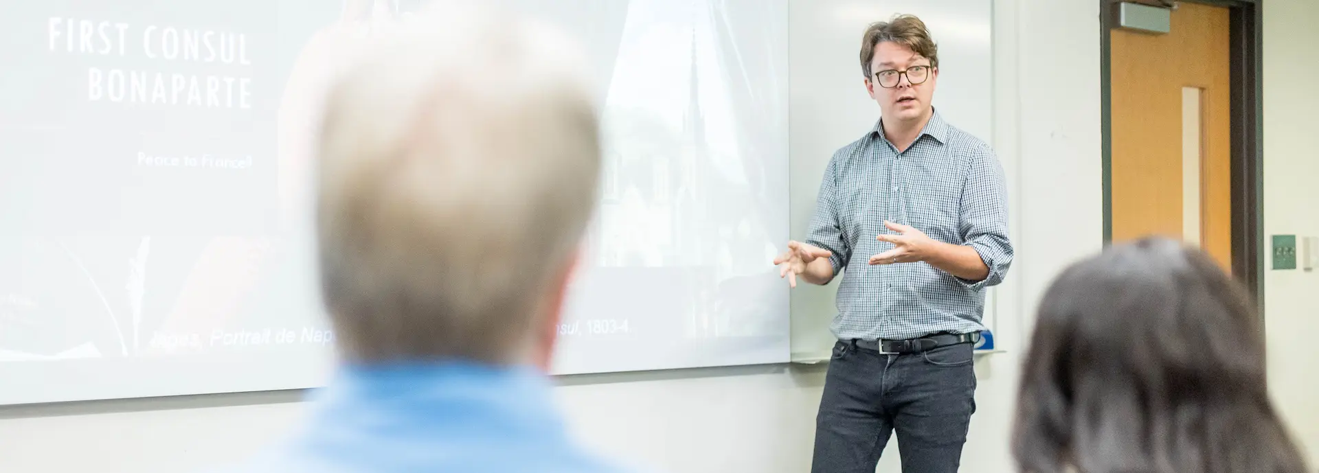 a happy professor at the front of a class teaching