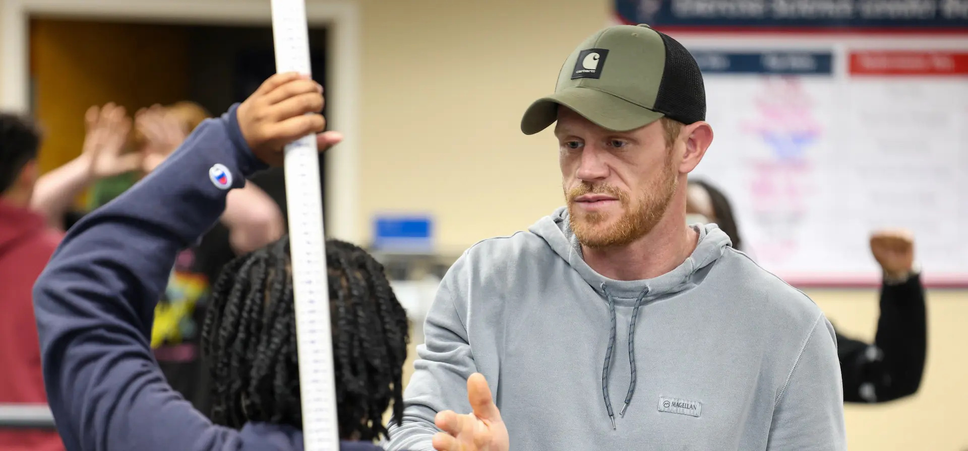 professor showing a student how to use exercise equipment