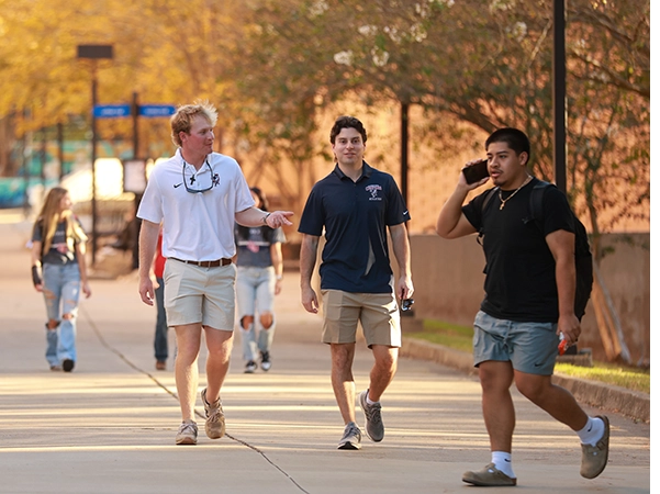 Students walking and talking with eachother on the way from their evening classes.