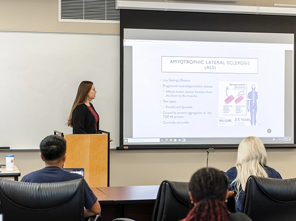 A professor giving a presentation to a classroom full of students.