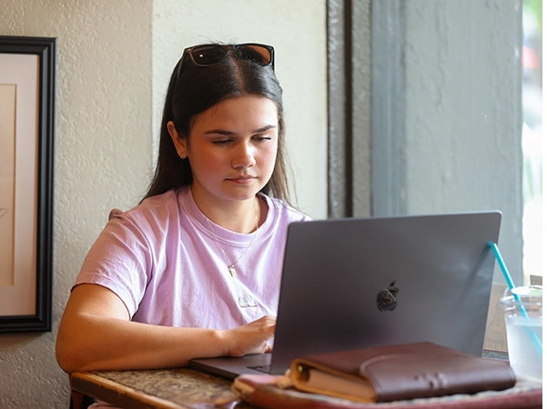 A student studying alone on her laptop.