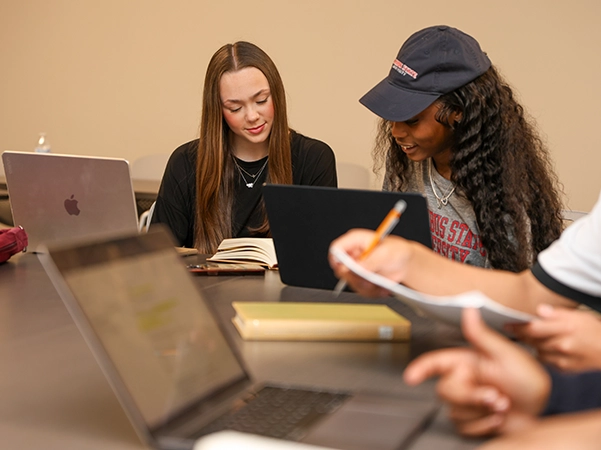 Two students studying together in the CSU library at a table