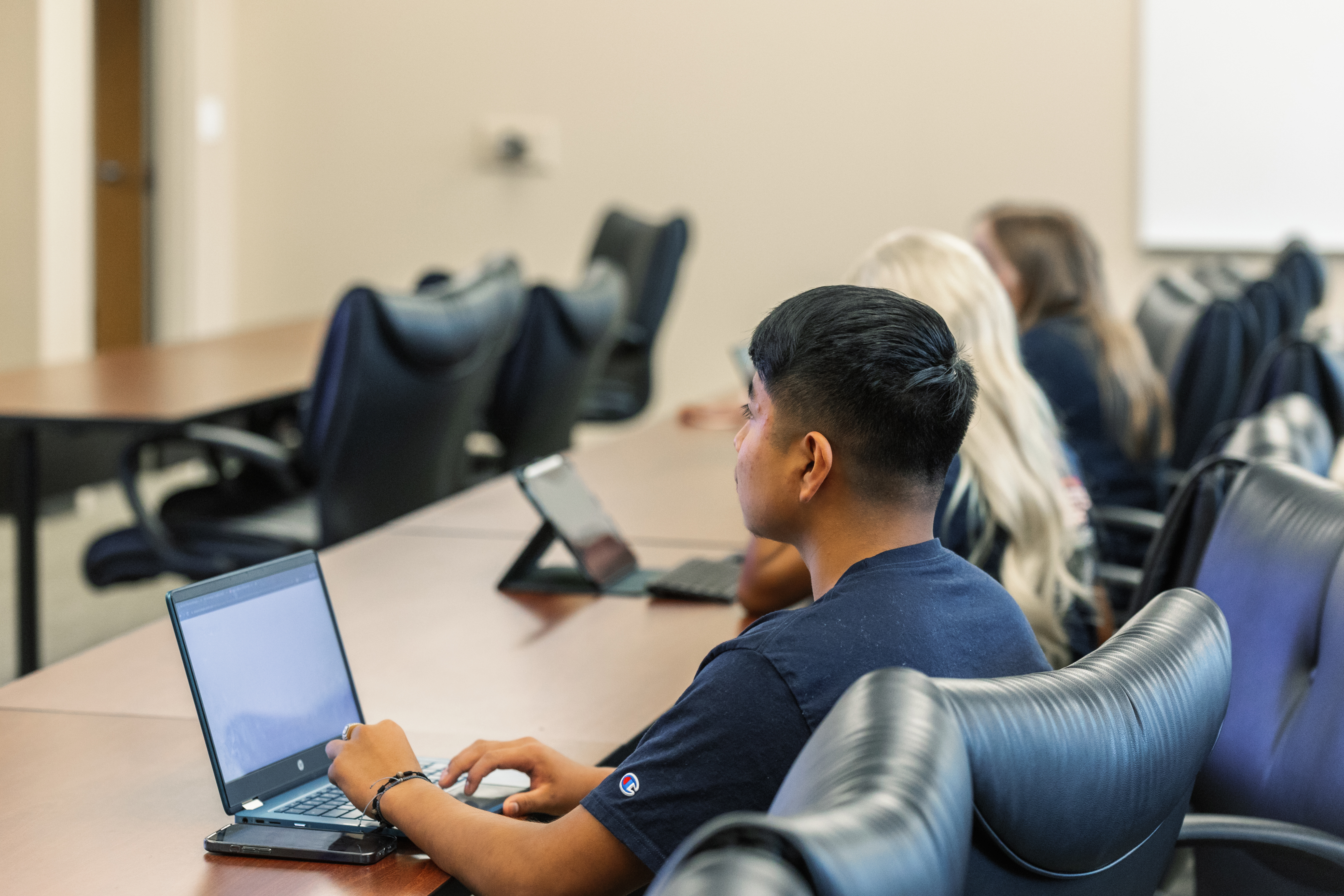 A student sitting in class, paying close attention to the lesson.