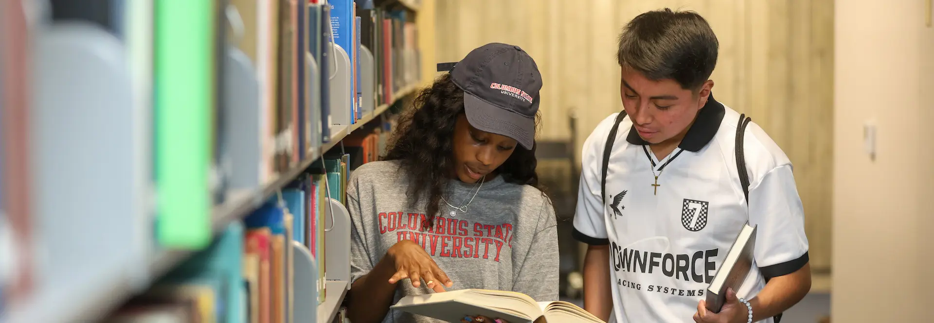 Two students standing in the library