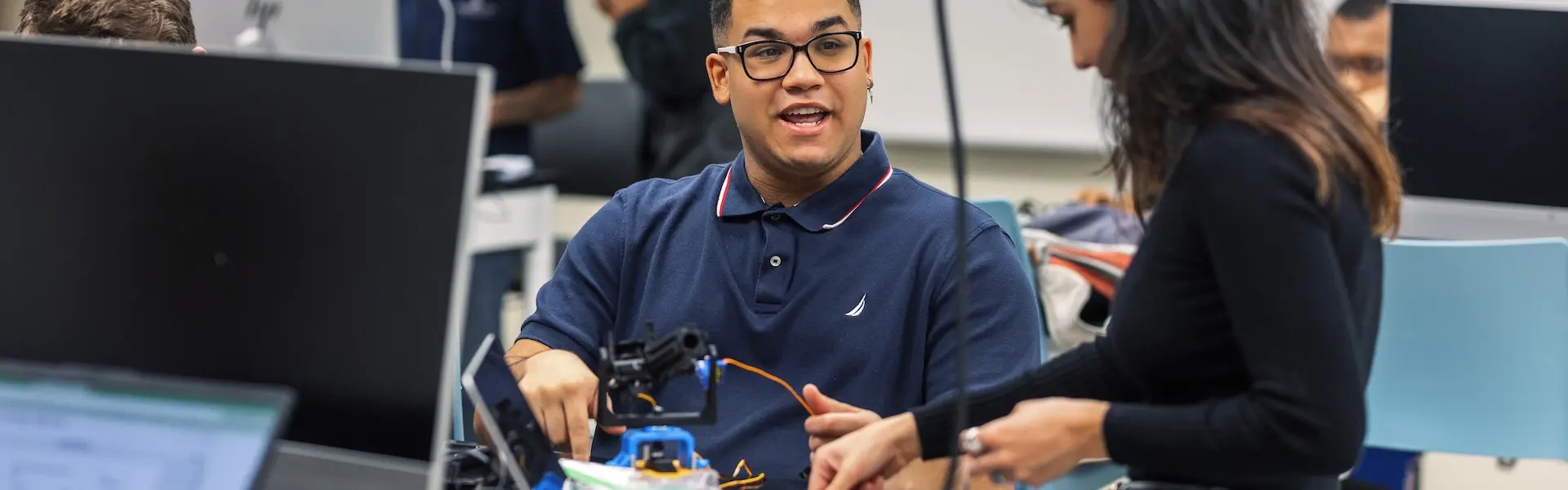 two students building a robot in a classroom