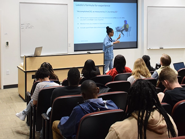 A professor giving a presentation in a classroom for her students.