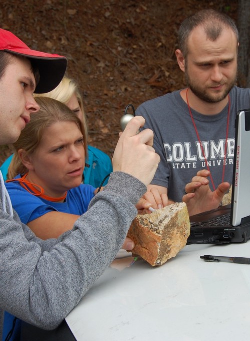 several students examining a rock