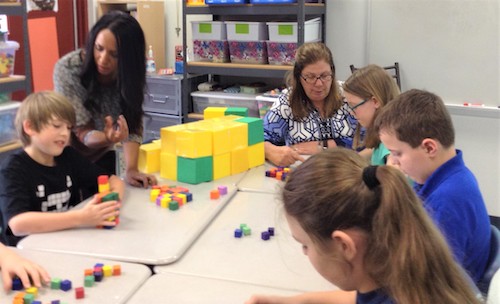 Teachers in a classroom teaching students with manipulatives