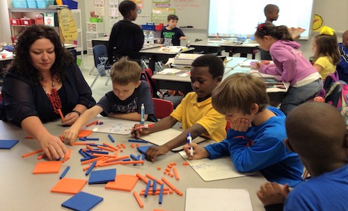 Teachers in a classroom teaching students with manipulatives