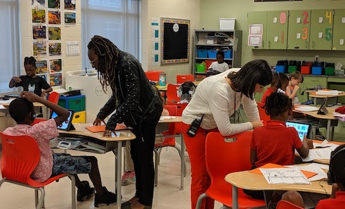 Teachers in a classroom teaching students with manipulatives