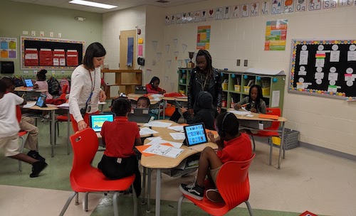 Teachers in a classroom teaching students with manipulatives