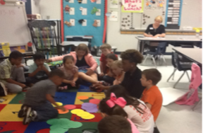 Teacher in a classroom teaching students with manipulatives