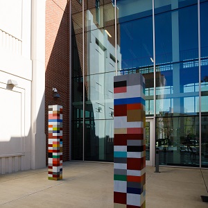 a large glass building with colorful pillars in front
