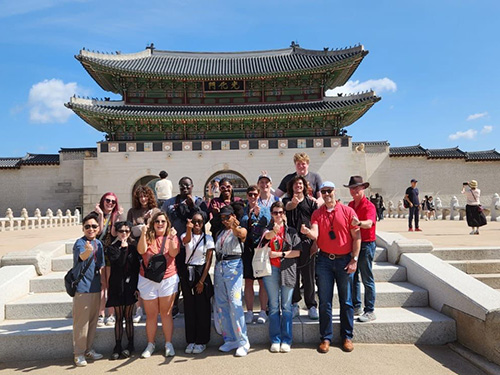 several people posing in front of a temple