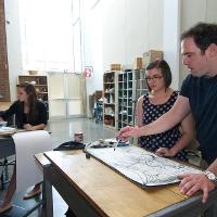 Two people working on an illustration 