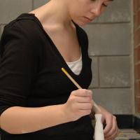 female student painting an object