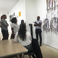 A discussion in an art gallery of a hanging artwork