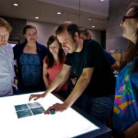 Students and a professor examining photo negatives